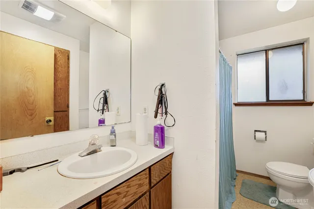 a bathroom with a sink vanity mirror and toilet