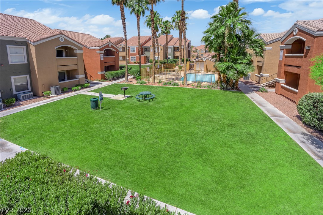 8101 West Flamingo Road, Unit 2152 Las Vegas, NV 89147 - Photo 26 of 45 A well-maintained lawn offers space for recreation and relaxation, complemented by a sparkling community pool.