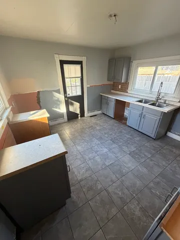 a large kitchen with kitchen island granite countertop a sink and a stove
