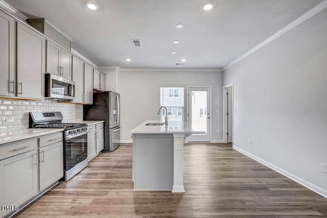 a kitchen with stainless steel appliances granite countertop a stove and wooden floor