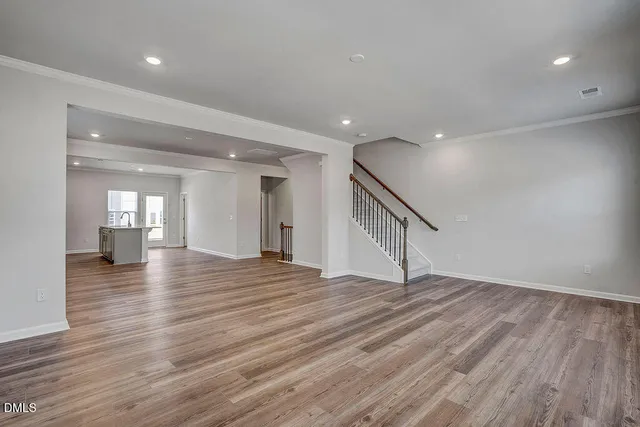 a view of empty room with wooden floor and stairs