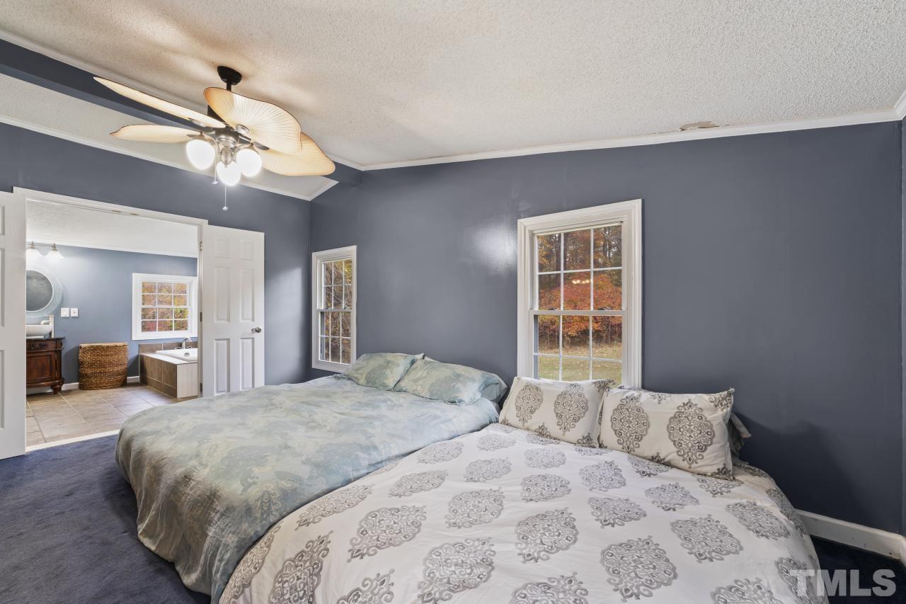 1231 Stoney Mountain Road Rougemont, NC 27572 - Photo 26 of 45 a bedroom with a large bed and a chandelier