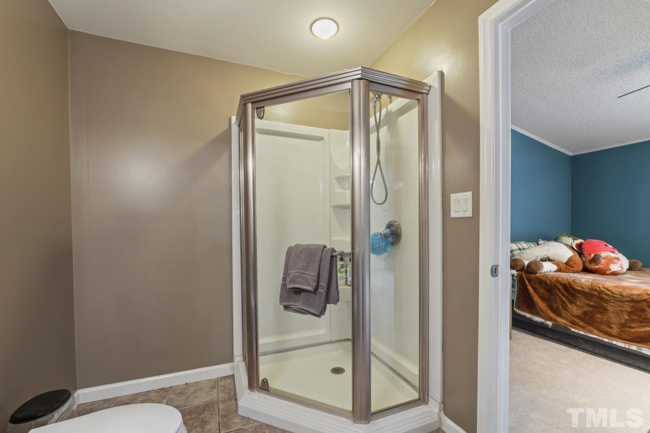 1231 Stoney Mountain Road Rougemont, NC 27572 - Photo 35 of 45 a bathroom with a glass shower door