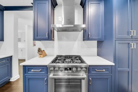 a kitchen with granite countertop a stove and a wooden cabinets