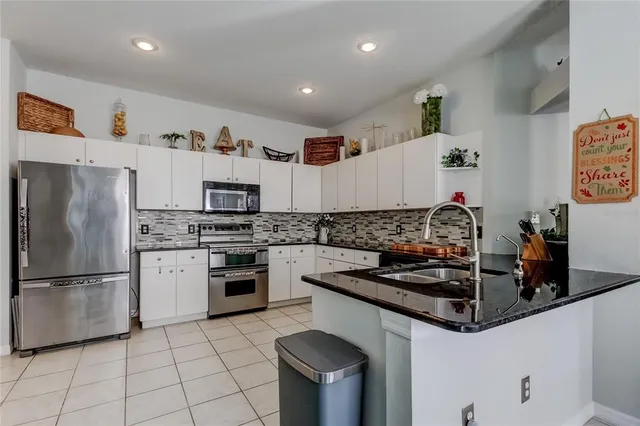 a kitchen with stainless steel appliances white cabinets and a sink