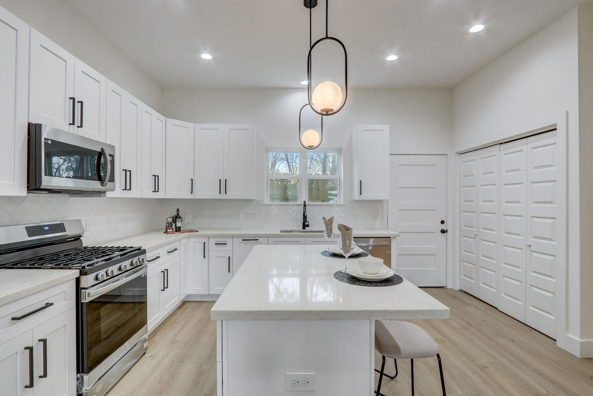 1211 Dewalt Street Houston, TX 77088 - Photo 8 of 28 a kitchen with kitchen island granite countertop a sink cabinets and wooden floor