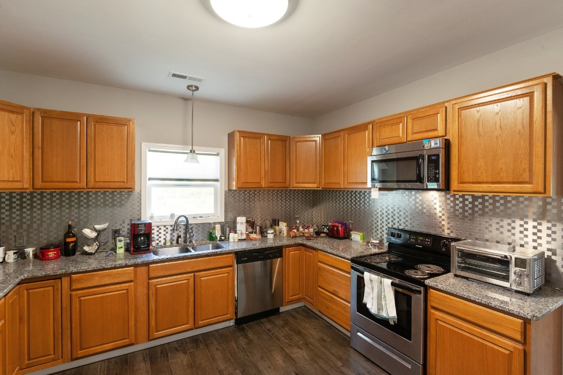 128 Murrell Road Dickson, TN 37055 - Photo 8 of 21 a kitchen with stainless steel appliances granite countertop a stove a sink a microwave and cabinets