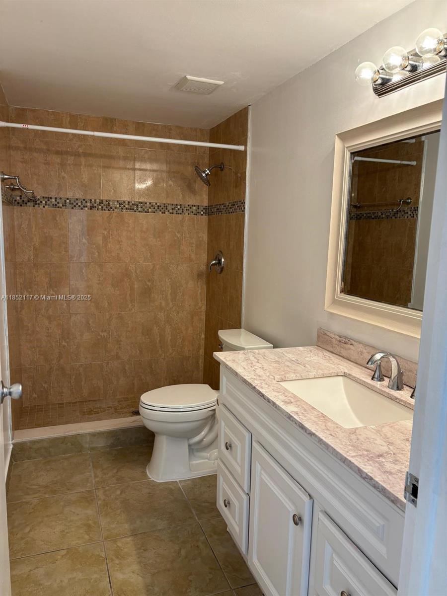 5656 Southwest 149th Place Miami, FL 33193 - Photo 13 of 28 a bathroom with a granite countertop sink toilet and shower