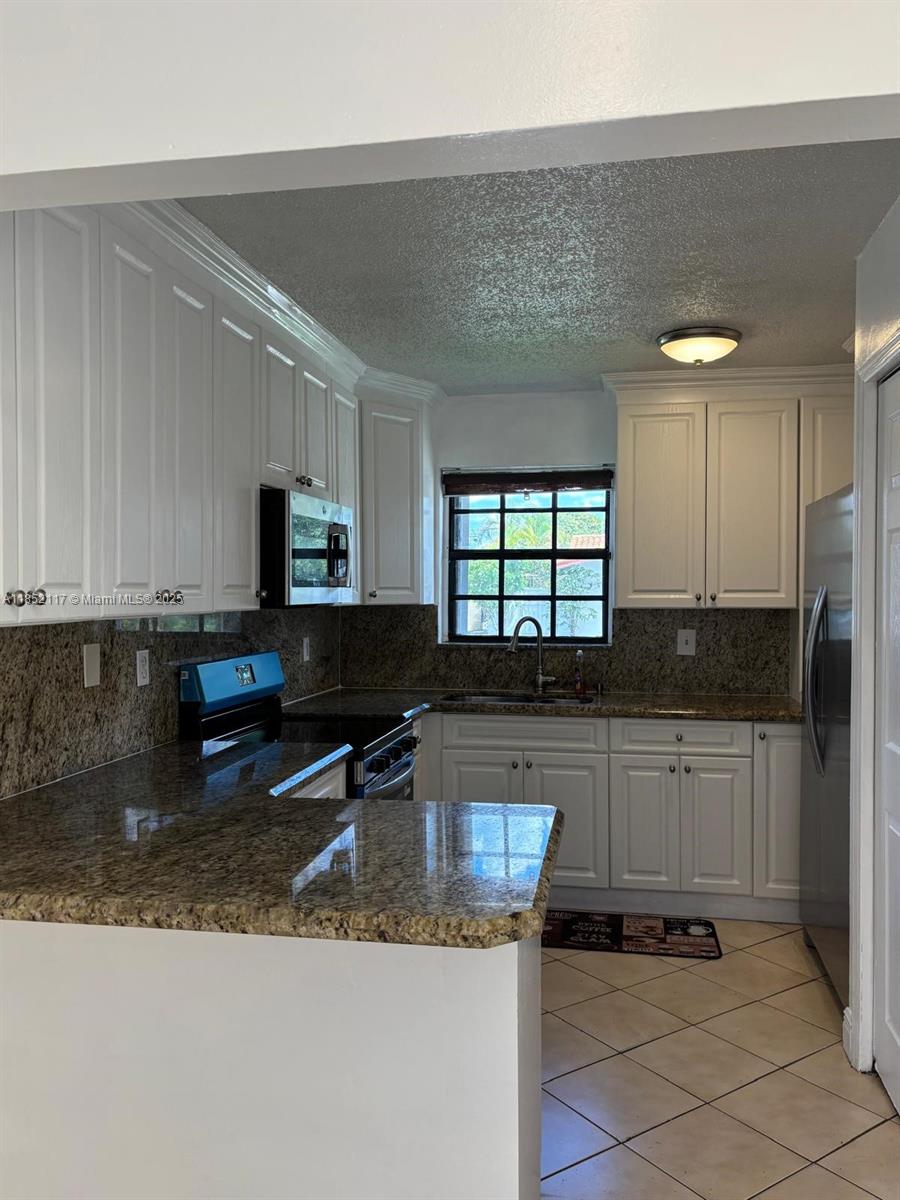 5656 Southwest 149th Place Miami, FL 33193 - Photo 8 of 28 a kitchen with granite countertop a stove a sink and a granite counter tops