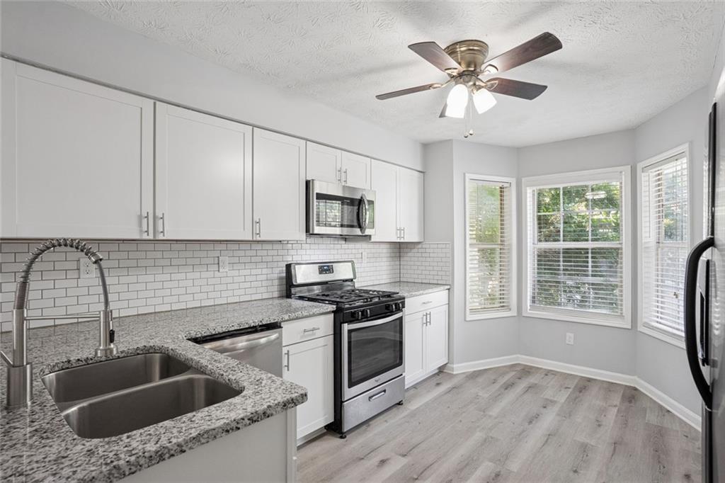 6430 Oakleaf Way Morrow, GA 30260 - Photo 2 of 23 a kitchen that has a sink cabinets counter space appliances and a window
