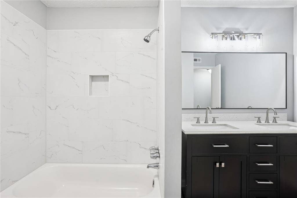 6430 Oakleaf Way Morrow, GA 30260 - Photo 3 of 23 a bathroom with a double vanity sink a mirror and a bathtub