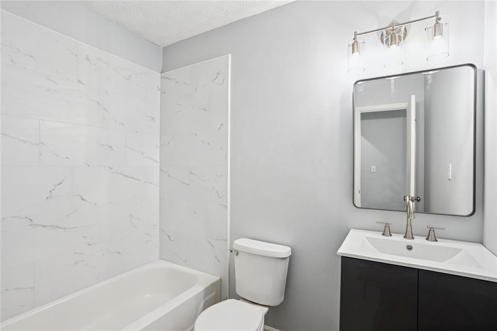 6430 Oakleaf Way Morrow, GA 30260 - Photo 5 of 23 a bathroom with a toilet a sink a mirror and bathtub