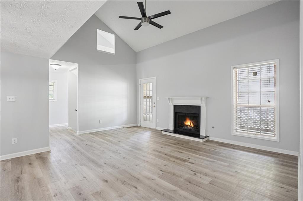 6430 Oakleaf Way Morrow, GA 30260 - Photo 8 of 23 an empty room with windows fireplace and wooden floor