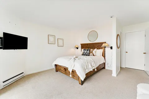 a spacious bedroom with a bed and a flat screen tv