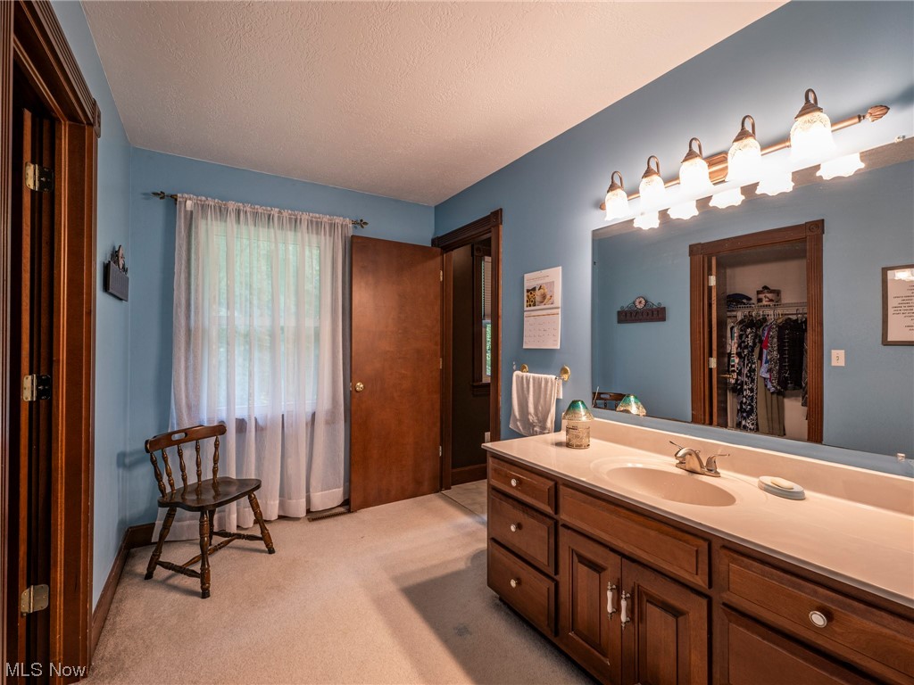 9452 Pleasant Hill Road Northwest Dundee, OH 44624 - Photo 18 of 35 Bathroom featuring vanity, mirror, and a textured ceiling