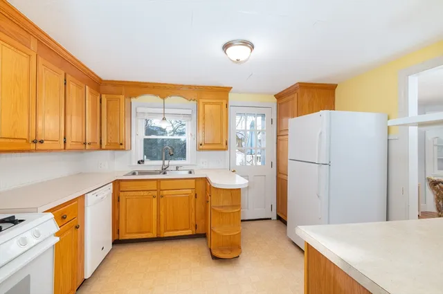 a kitchen with stainless steel appliances granite countertop a sink a stove and a refrigerator with wooden cabinets