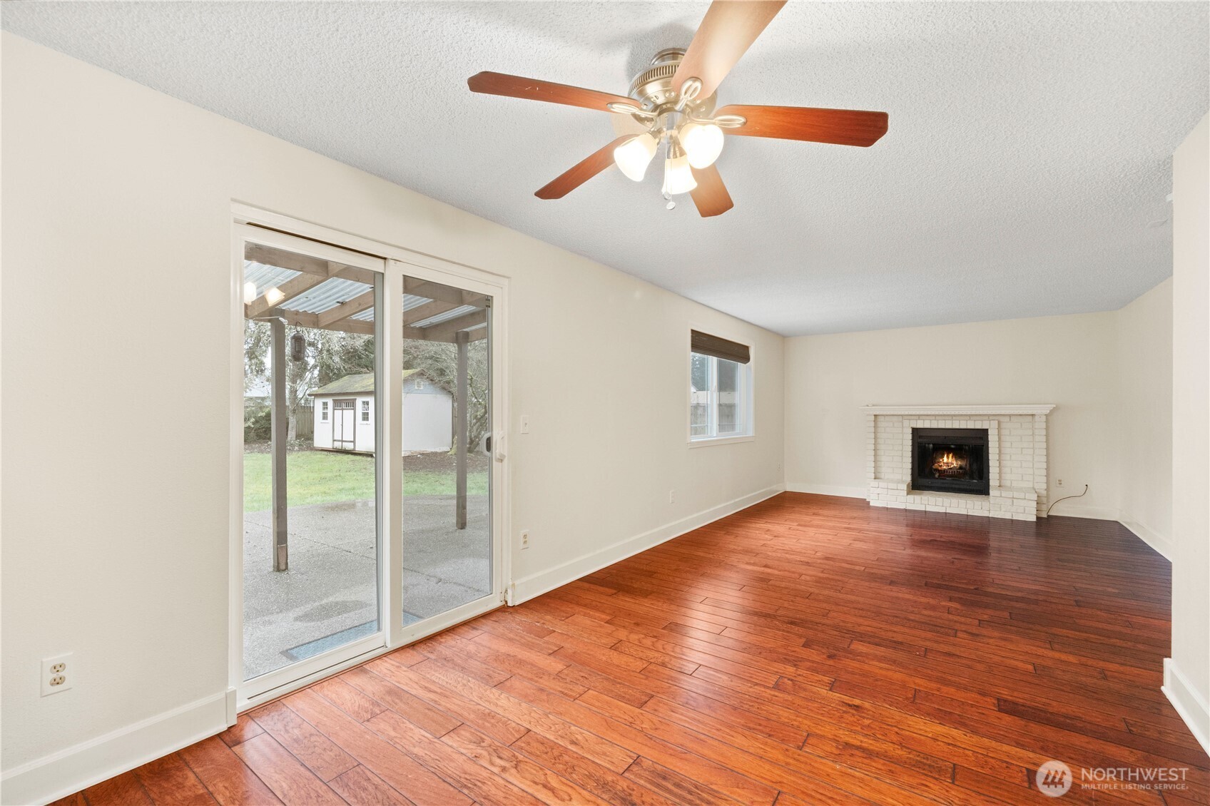 832 Torrey Street Southeast Olympia, WA 98513 - Photo 8 of 27 an empty room with wooden floor chandelier fan and windows