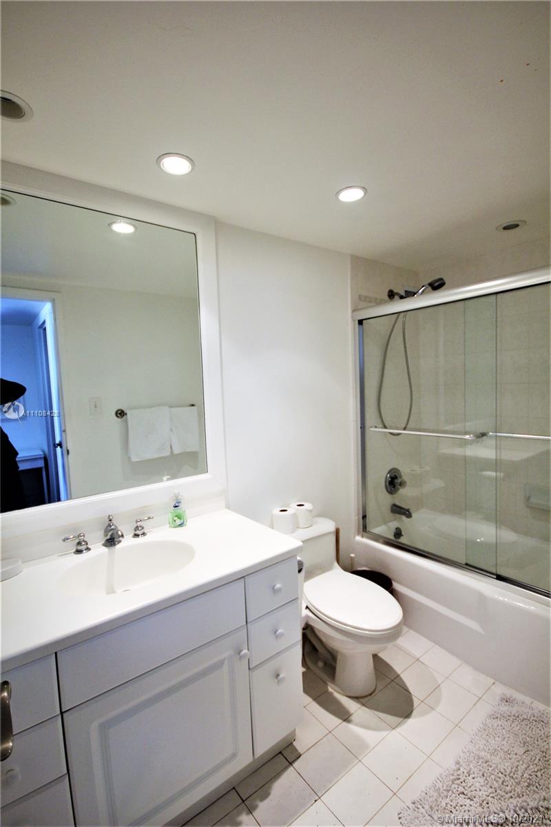 5161 Collins Avenue, Unit 711 Miami Beach, FL 33140 - Photo 14 of 67 a bathroom with a double vanity sink toilet mirror and shower