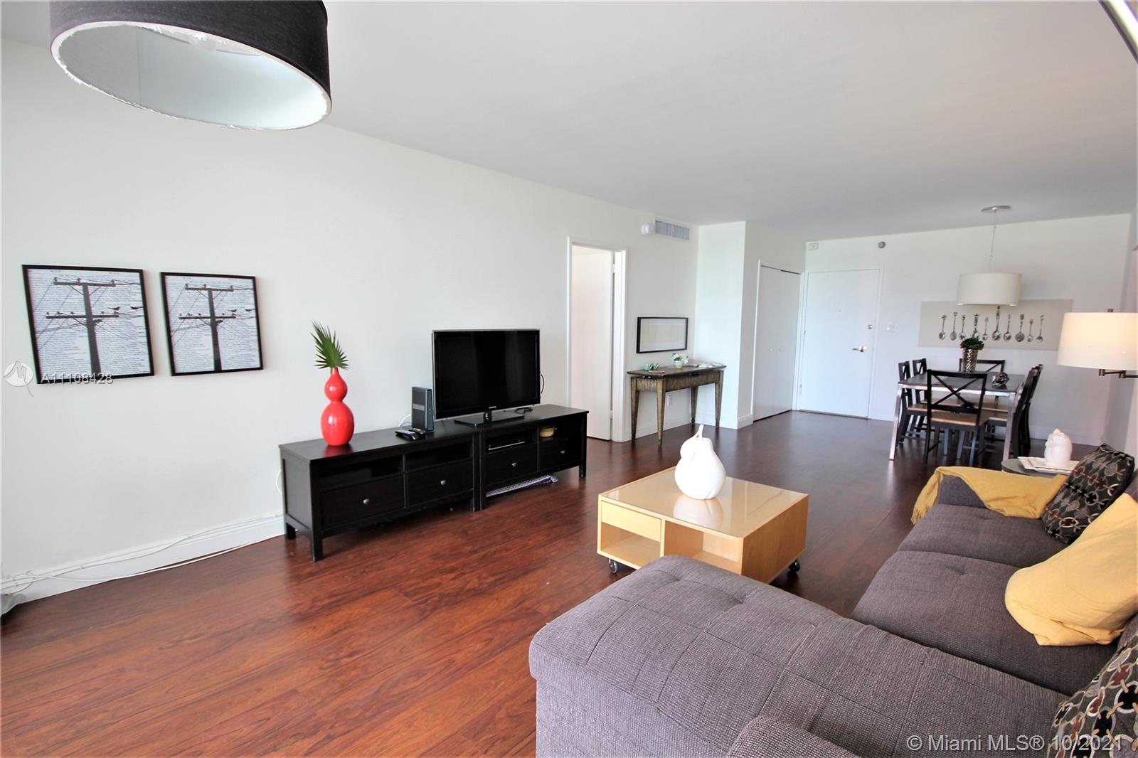 5161 Collins Avenue, Unit 711 Miami Beach, FL 33140 - Photo 3 of 67 a living room with furniture and a flat screen tv