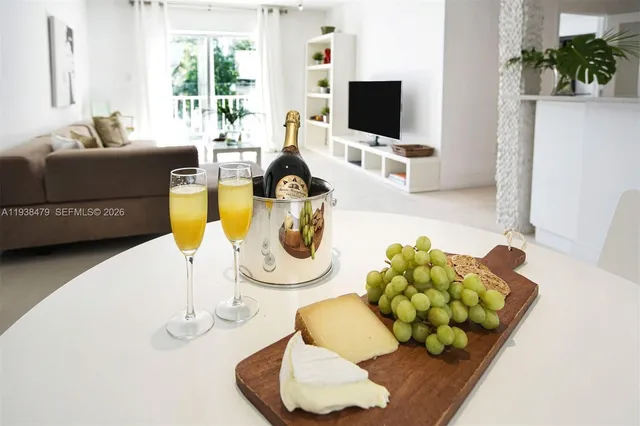 a living room with furniture a flat screen tv and a floor to ceiling window