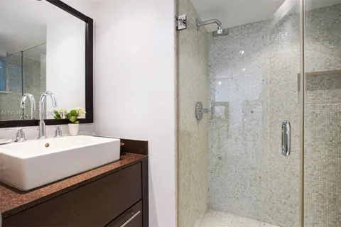 a bathroom with a sink a mirror and shower