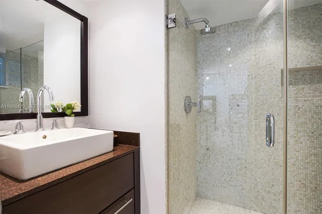 a bathroom with a sink a mirror and shower
