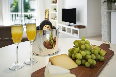 a living room with stainless steel appliances furniture and a flat screen tv