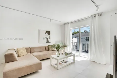 a living room with furniture and a glass door