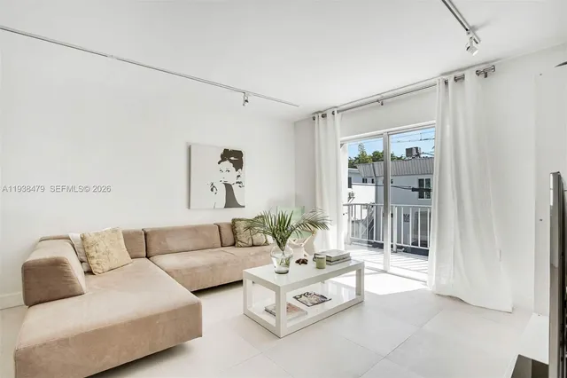 a living room with furniture and a glass door