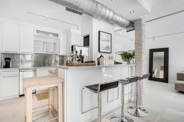 a kitchen with cabinets and chairs