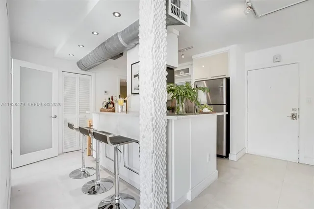a view of kitchen with furniture and refrigerator