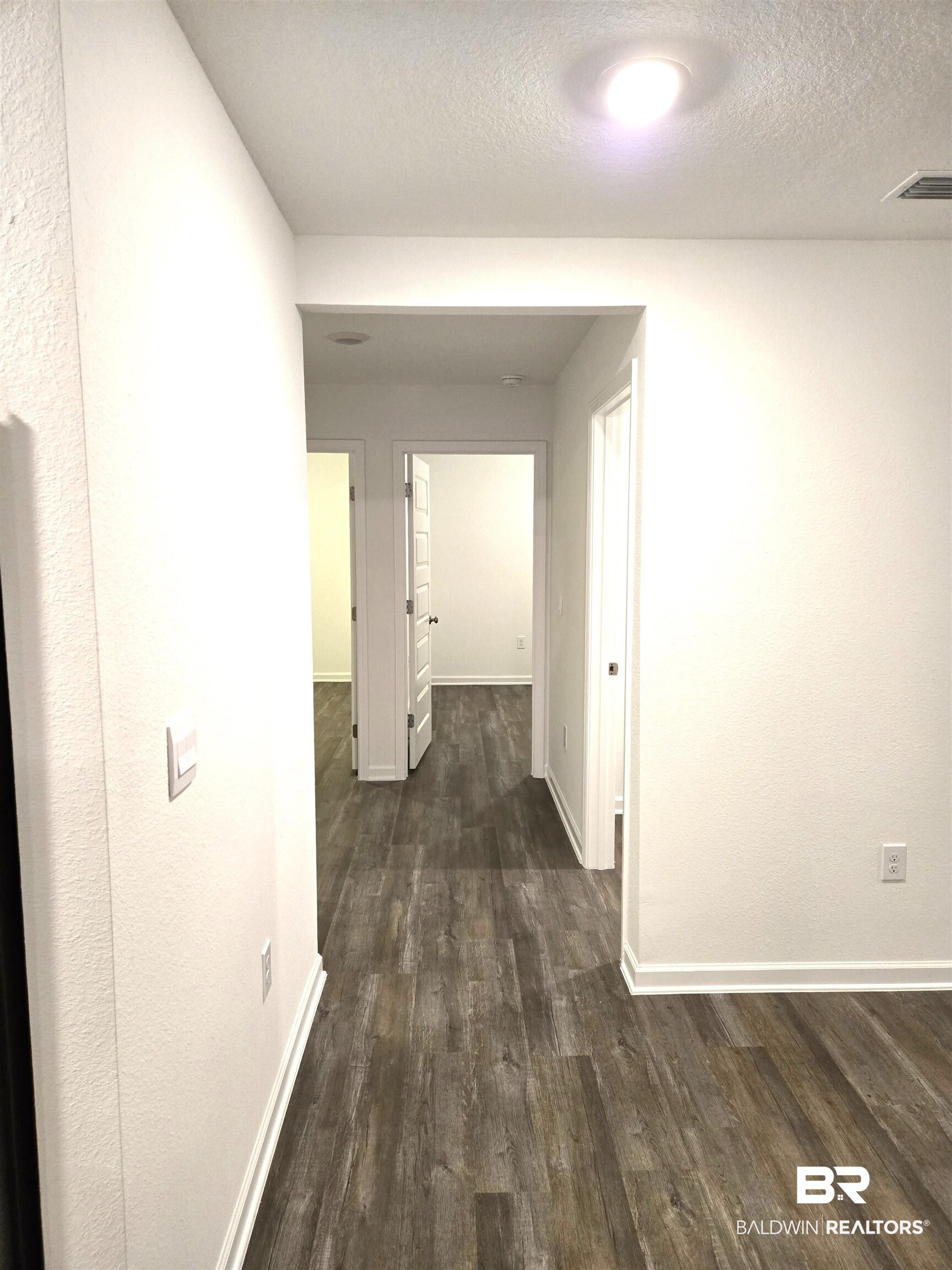 24321 Ringneck Loop Elberta, AL 36530 - Photo 16 of 39 Corridor with a textured ceiling and dark hardwood / wood-style floors