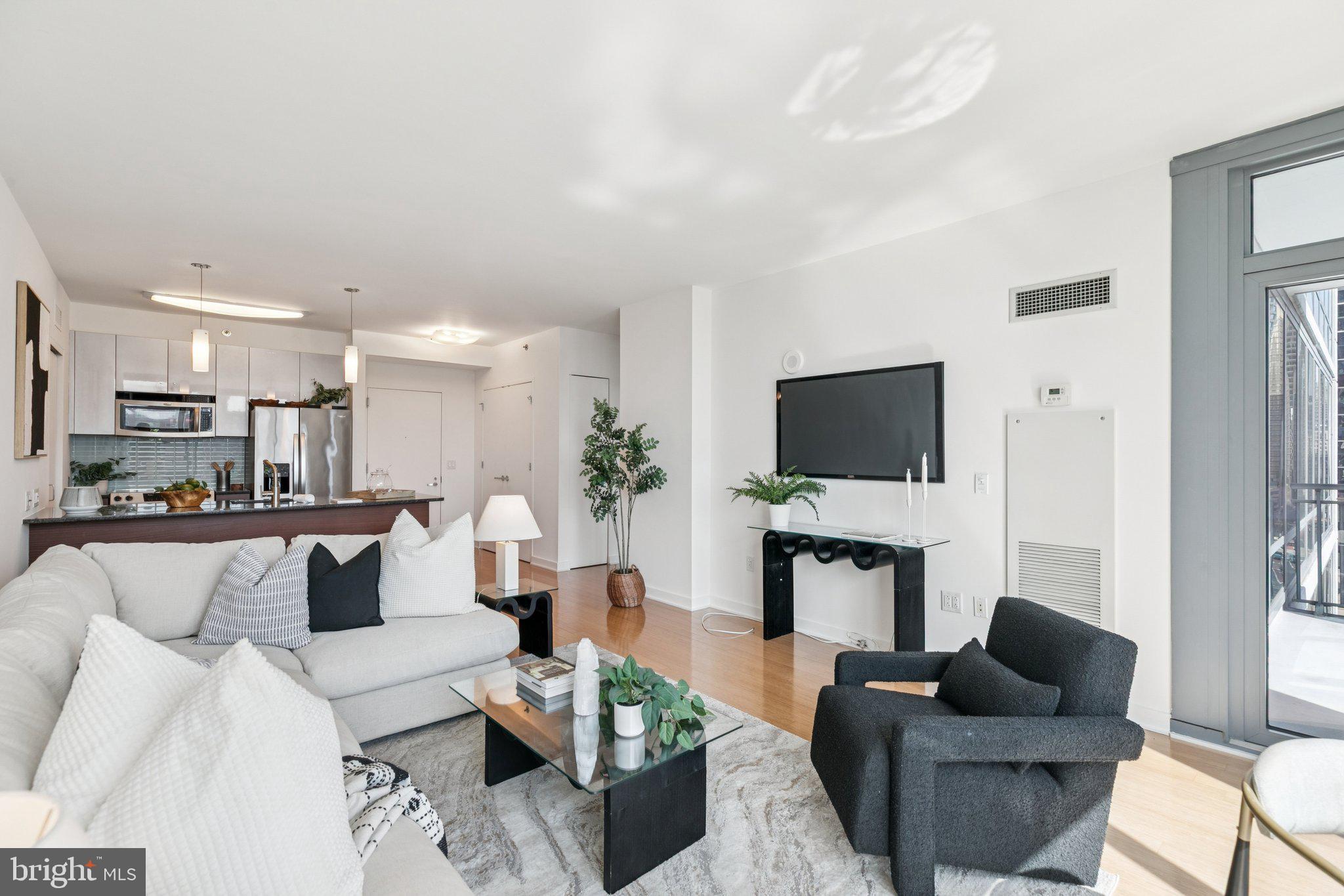 2101 Market Street, Unit 905 Philadelphia, PA 19103 - Photo 6 of 30 a living room with furniture a flat screen tv and a fireplace