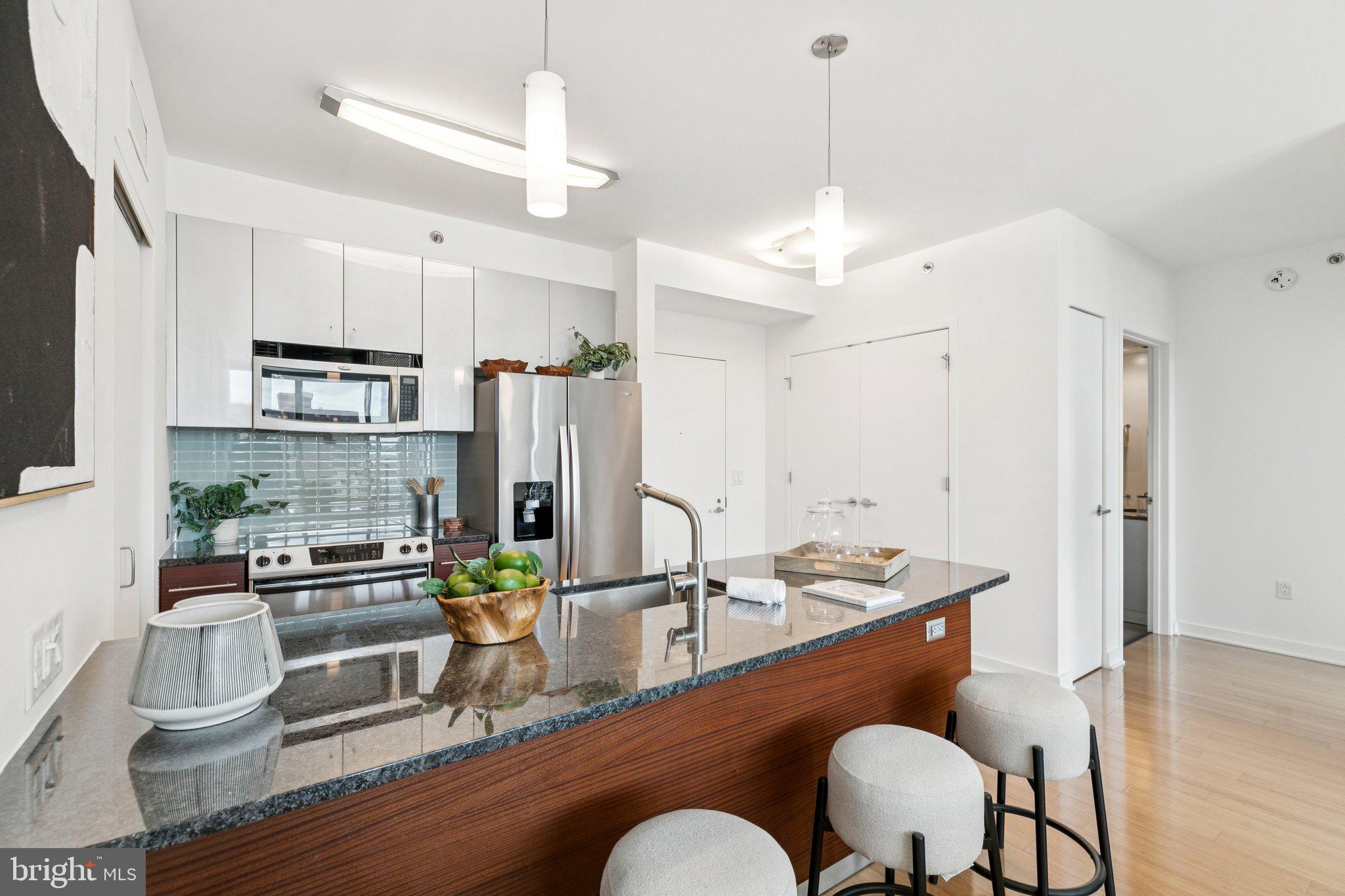 2101 Market Street, Unit 905 Philadelphia, PA 19103 - Photo 9 of 30 a kitchen with stainless steel appliances granite countertop a sink refrigerator and cabinets
