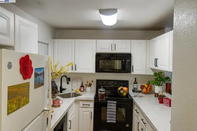 a kitchen with a sink dishwasher stove and cabinets