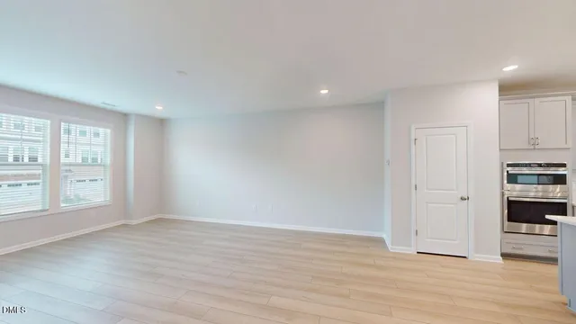 a view of a big room with wooden floor and windows
