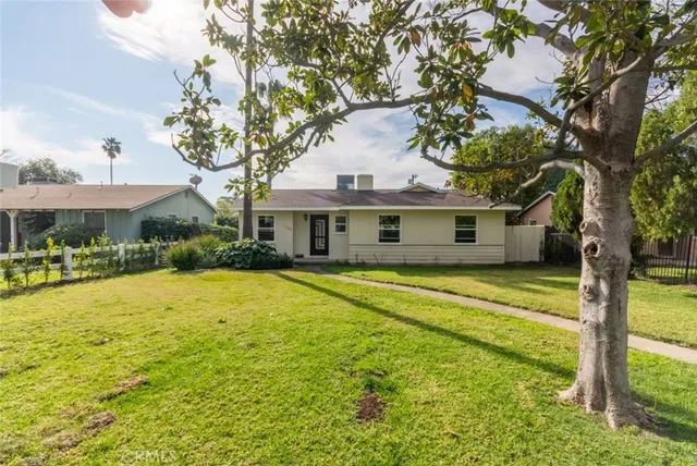 a front view of a house with a yard table and chairs under an umbrella