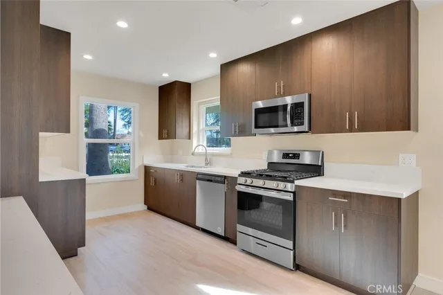a kitchen with stainless steel appliances a stove a sink and a refrigerator