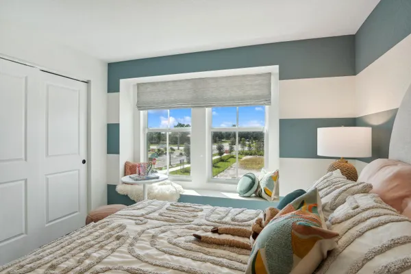 a bedroom with a bed and a large window