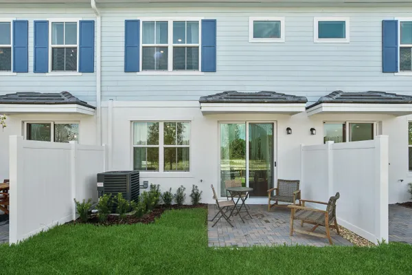 a backyard of a house with table and chairs
