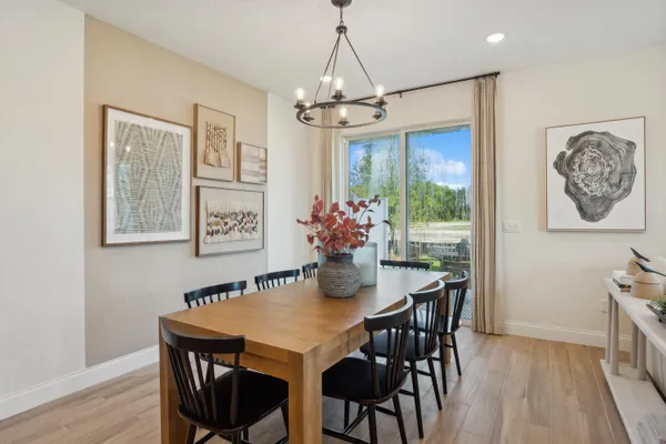 a dining room with furniture a chandelier and wooden floor
