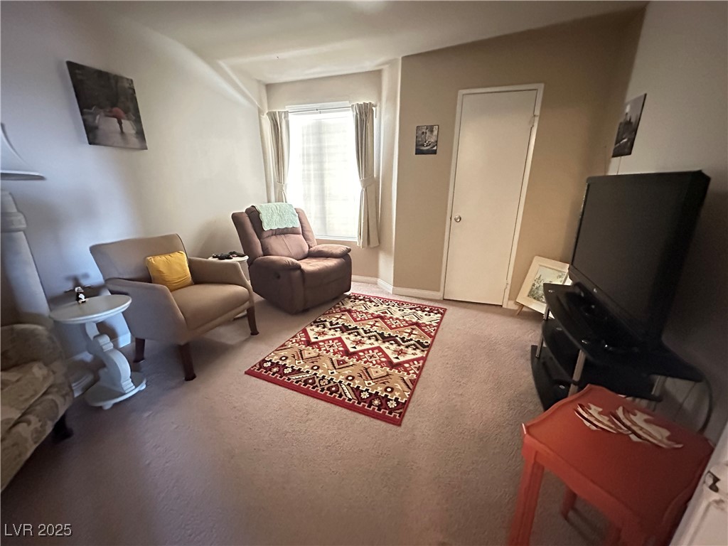 698 South Racetrack Road, Unit 322 Henderson, NV 89015 - Photo 21 of 39 Living area featuring carpet floors and baseboards