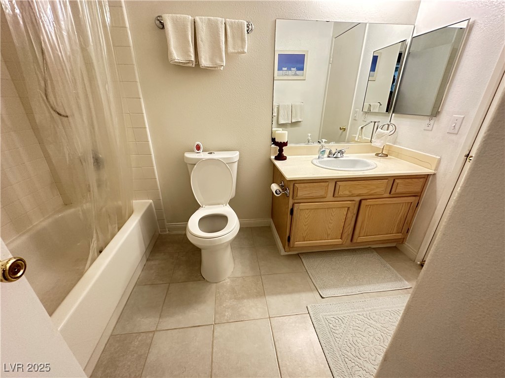 698 South Racetrack Road, Unit 322 Henderson, NV 89015 - Photo 23 of 39 Bathroom featuring tile patterned flooring, vanity, toilet, shower / bath combo with shower curtain, and baseboards