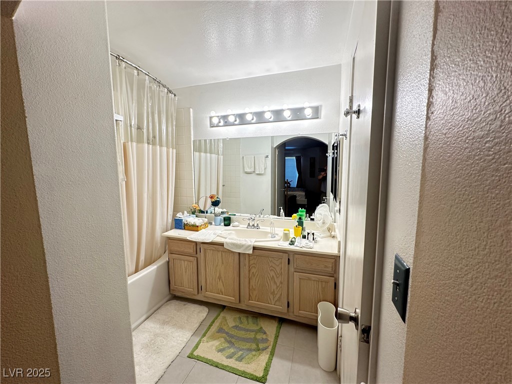 698 South Racetrack Road, Unit 322 Henderson, NV 89015 - Photo 25 of 39 Bathroom featuring vanity, a textured wall, shower / bathtub combination with curtain, and tile patterned flooring
