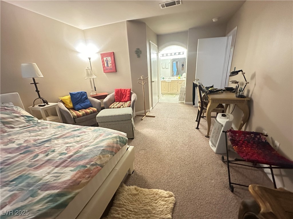 698 South Racetrack Road, Unit 322 Henderson, NV 89015 - Photo 27 of 39 Bedroom featuring visible vents, baseboards, ensuite bath, and light carpet