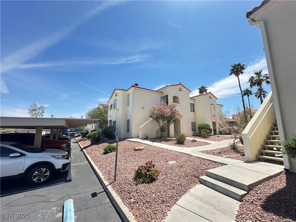 698 South Racetrack Road, Unit 322 Henderson, NV 89015 - Photo 36 of 39 View of home's exterior with covered parking, stucco siding, and a residential view