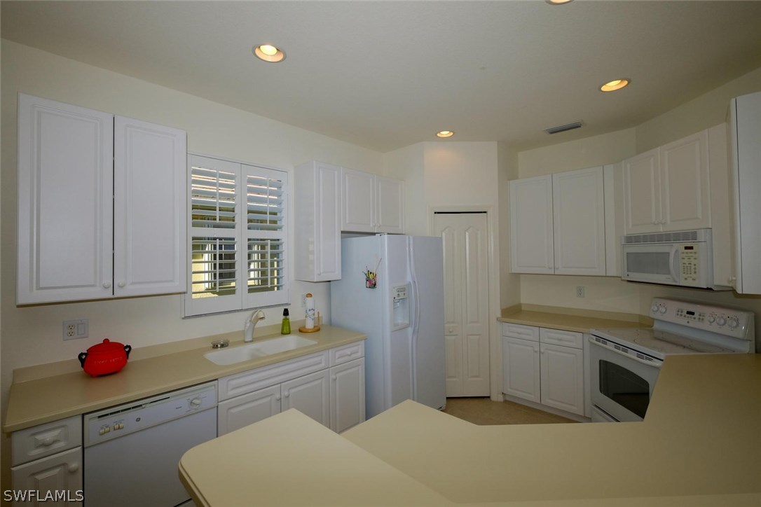 4717 Fairloop Run Lehigh Acres, FL 33973 - Photo 8 of 20 a kitchen that has a sink cabinets counter space and appliances