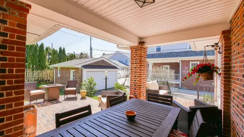 a view of a patio with couches and pool table and chairs with wooden floor and fence
