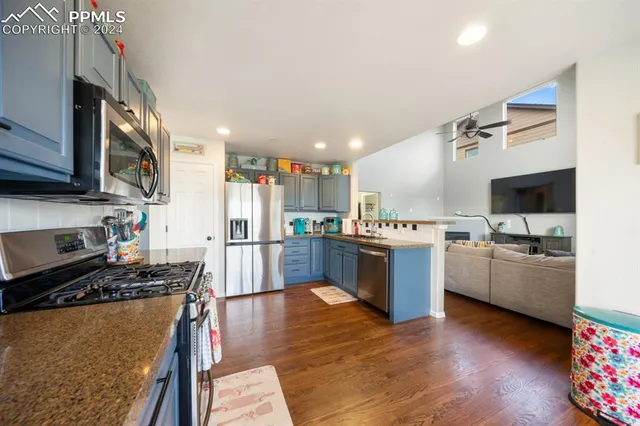 a kitchen with stainless steel appliances kitchen island granite countertop a stove a sink a refrigerator and a microwave