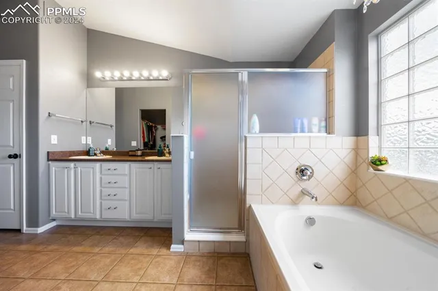 a bathroom with a tub a sink and a window